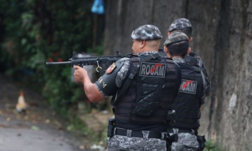Policiais ROCAM em ação, com fuzil em punho, em local não especificado.