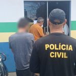 Policial civil com uniforme preto, em frente a uma delegacia, com presos.