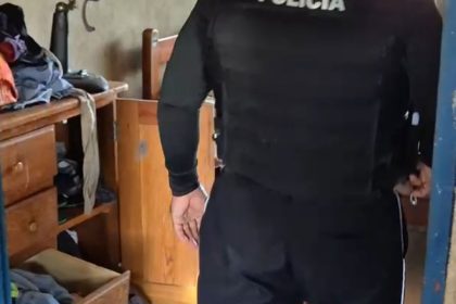 Policial fardado em ação, entrando em cômodo.