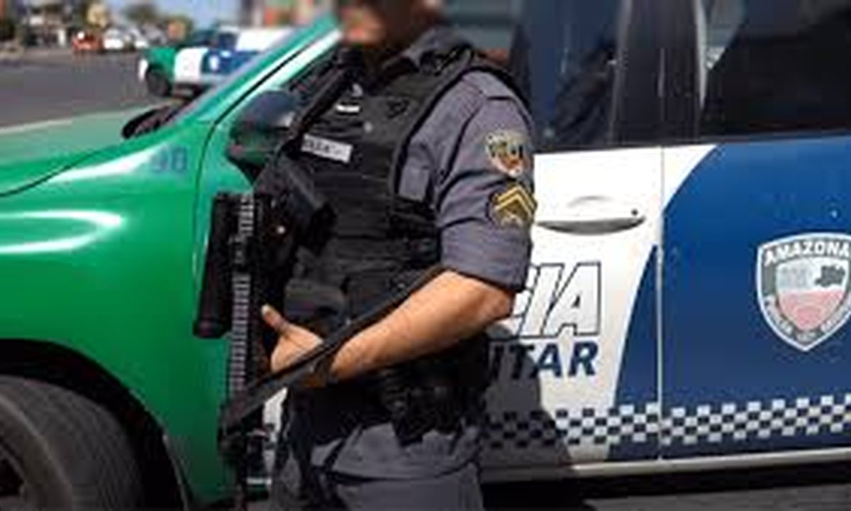 Policial militar em frente a viatura da Polícia Militar do Amazonas, com fuzil.