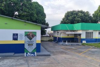 Prédios com cores verde, branco, azul e amarelo, com aviso sobre violência contra idosos e acessibilidade.