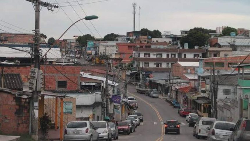 Rua em favela no Morro da Liberdadscom casas de tijolos e fios elétricos, carros e céu nublado.