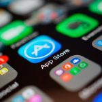 Tela de iPhone com ícones de aplicativos, incluindo App Store, redes sociais e Google.