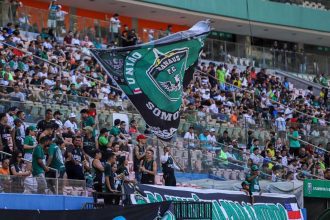 Torcedores do Manaus FC em um jogo, com bandeira do clube.
