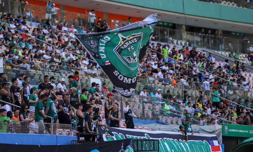 Torcedores do Manaus FC em um jogo, com bandeira do clube.