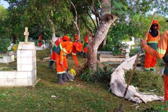 Trabalhadores limpando um cemitério em Manaus para o Dia dos Pais.