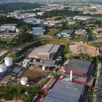 Vista aérea da Zona Franca de Manaus, com edifícios industriais e áreas verdes.