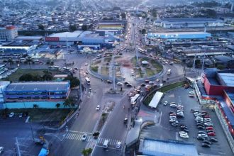 Vista aérea de cidade com trânsito intenso e edifícios comerciais.