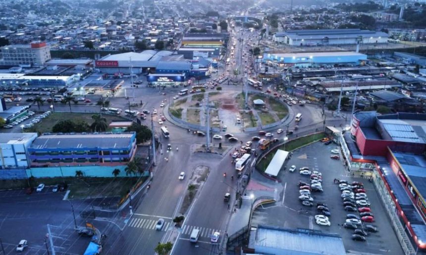 Vista aérea de cidade com trânsito intenso e edifícios comerciais.