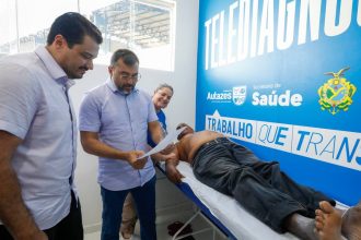 Wilson Lima implanta Telessaúde em Autazes, com equipe médica examinando paciente.