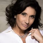 Zizi Possi sorrindo, usando colar e camisa branca