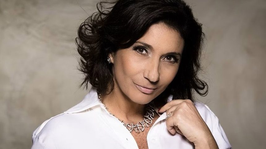 Zizi Possi sorrindo, usando colar e camisa branca