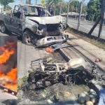 Acidente de trânsito com veículo e moto em chamas, com frutas espalhadas na via.