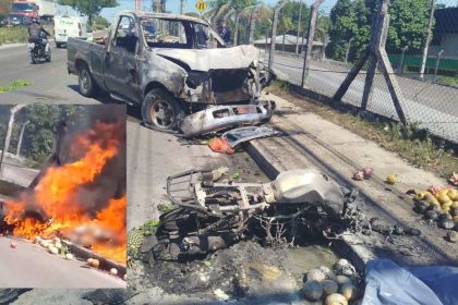 Acidente de trânsito com veículo e moto em chamas, com frutas espalhadas na via.