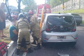 Acidente na Avenida Efigênio Salles: motociclista ferido e carro danificado com bombeiros prestando socorro.