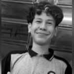 Adolescente sorrindo, em preto e branco.