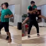 Amigos se divertem em cena engraçada, recriando movimentos de luta de forma cômica.