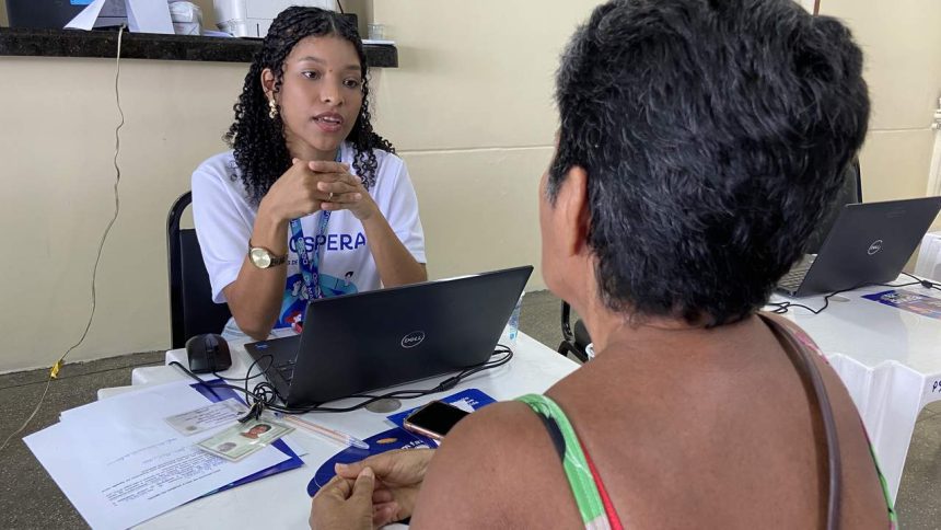 Assistente orienta cidadã em mutirão de serviços, com foco em tarifa social da água.