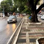 Avenida Getúlio Vargas com carros e ônibus em via molhada.