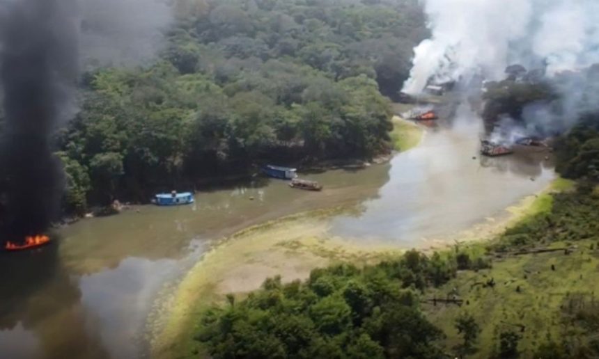 Barcos em chamas em rio na Amazônia, com fumaça negra e branca.