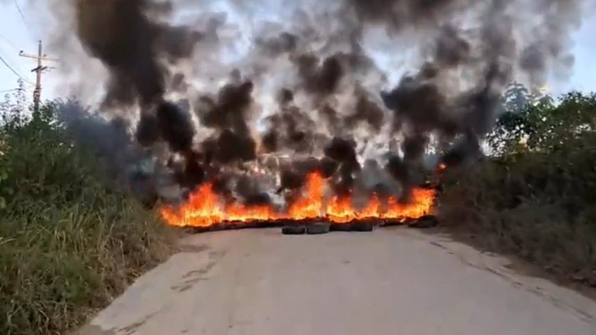 Ramal do Brasileirinho: Barreira de fogo bloqueia estrada, com muita fumaça escura e chamas intensas.