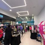 Bazar de roupas e acessórios em shopping, com balão inflável rosa e branco e fachada da loja Ponto Fast.