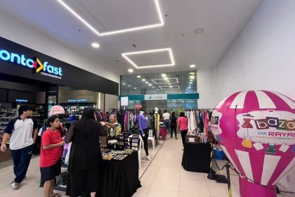 Bazar de roupas e acessórios em shopping, com balão inflável rosa e branco e fachada da loja Ponto Fast.