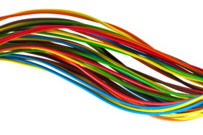 Cabos elétricos e fio fios coloridos emaranhados em fundo branco.