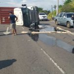 Carreta com contêiner tombada na avenida Governador José Lindoso, com policiais no local.