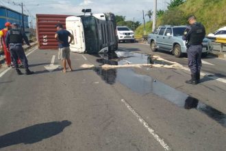 Carreta com contêiner tombada na avenida Governador José Lindoso, com policiais no local.