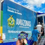Carreta da Saúde do Governo do Amazonas com pessoas entrando para atendimento.