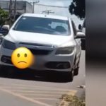 Carro branco estacionado na rua com emoji triste. Cena em Paraíso, Rua Presidente Floriano Peixoto.