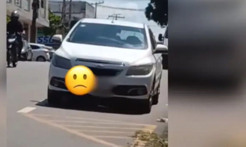 Carro branco estacionado na rua com emoji triste. Cena em Paraíso, Rua Presidente Floriano Peixoto.