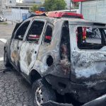 Carro destruído por incêndio em rua de Manaus, mostrando danos extensos.