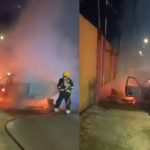 Carro em chamas após explosão em Manaus, bombeiro combatendo o fogo.