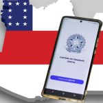 Celular com aplicativo Carteira de Trabalho Digital sobre mapa do Amazonas com bandeira para falar sobre postos de trabalho