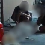 Cena em ambiente interno com pessoas. Detalhes incluem elementos do ambiente.