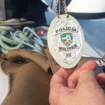 Distintivo da Polícia Militar AM em mãos de investigadora.