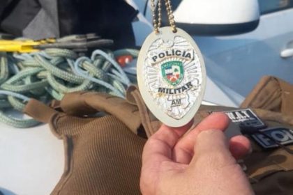 Distintivo da Polícia Militar AM em mãos de investigadora.