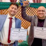 Dois homens sorrindo com diplomas em mãos, comemorando a conquista. Prefeito e vice-prefeito de Caapiranga cassados.