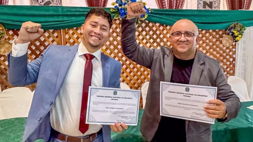 Dois homens sorrindo com diplomas em mãos, comemorando a conquista. Prefeito e vice-prefeito de Caapiranga cassados.
