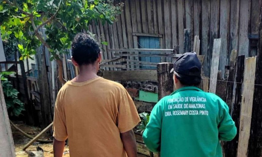 Dois indivíduos observando uma construção de madeira, possivelmente em contexto de vigilância em saúde.