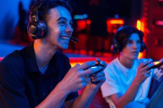 Dois jovens gamers jogando videogame com fones de ouvido e controles