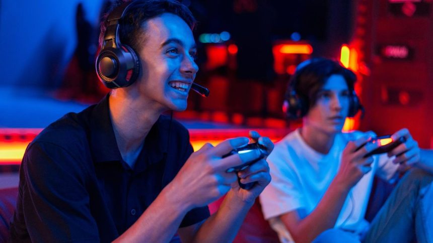 Dois jovens gamers jogando videogame com fones de ouvido e controles
