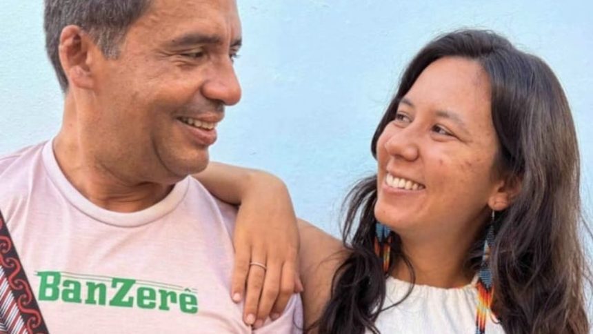 Duas pessoas sorrindo, com um homem usando uma camiseta com a palavra 'Banzerê'.