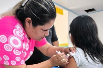 Enfermeira aplicando vacina HPV em criança.