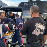 Equipe de resgate da SSP-AM transporta policial militar acidentado em helicóptero.