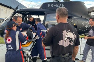 Equipe de resgate da SSP-AM transporta policial militar acidentado em helicóptero.