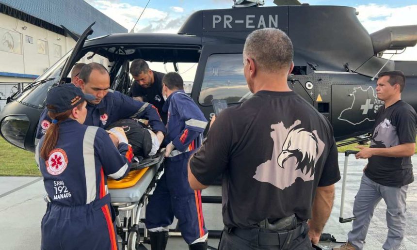 Equipe de resgate da SSP-AM transporta policial militar acidentado em helicóptero.