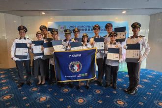 Estudantes do Amazonas com medalhas em olimpíada de matemática no Japão, exibindo diplomas e bandeira da escola.